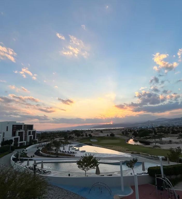 a view of a resort with a pool and a sunset at Ayla golf in Aqaba