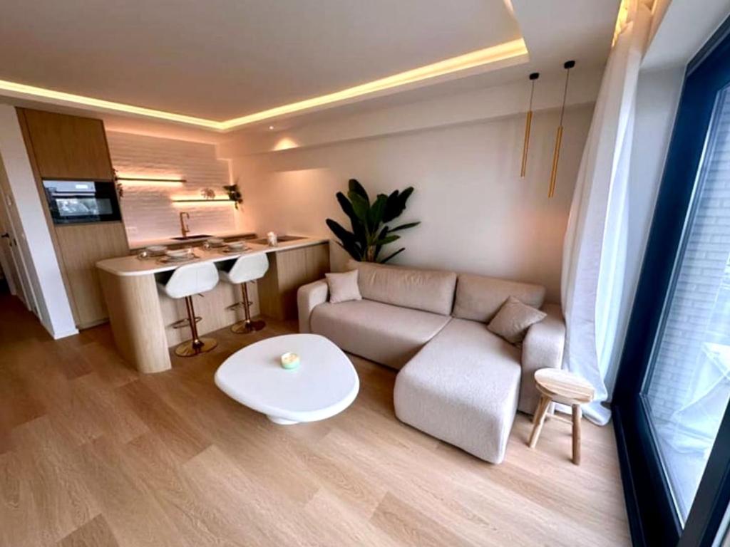 a living room with a couch and a table at Luxury apartment with sea view in Westende-Bad