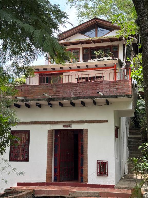 a house with a red door and stairs at Hospedaje Casa Renasiente - Guest house in Cali