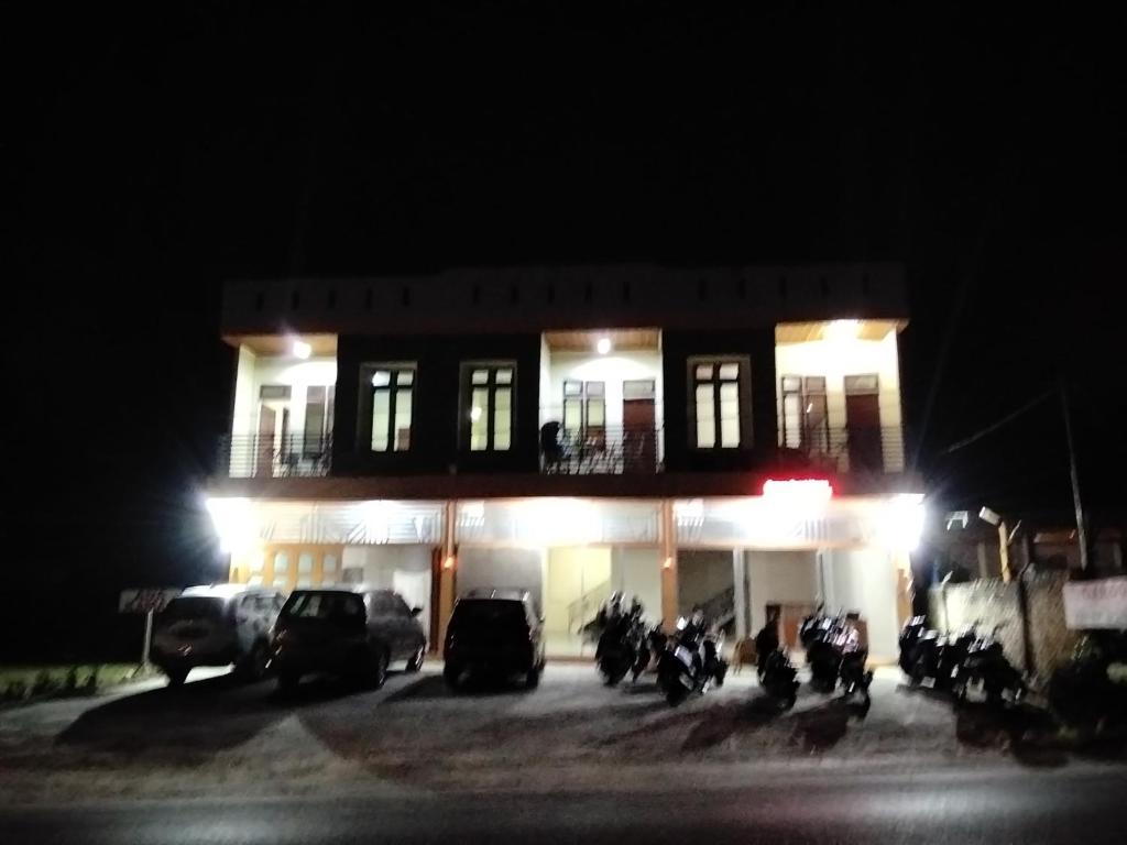 a group of motorcycles parked in front of a building at night at GAROGA Guest House in Ambarita