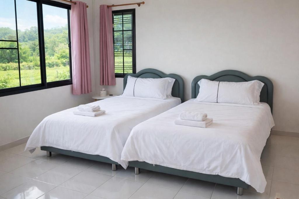 two beds in a room with two windows at Phu Man Mhok Khao Yai in Ban Nong Takhain
