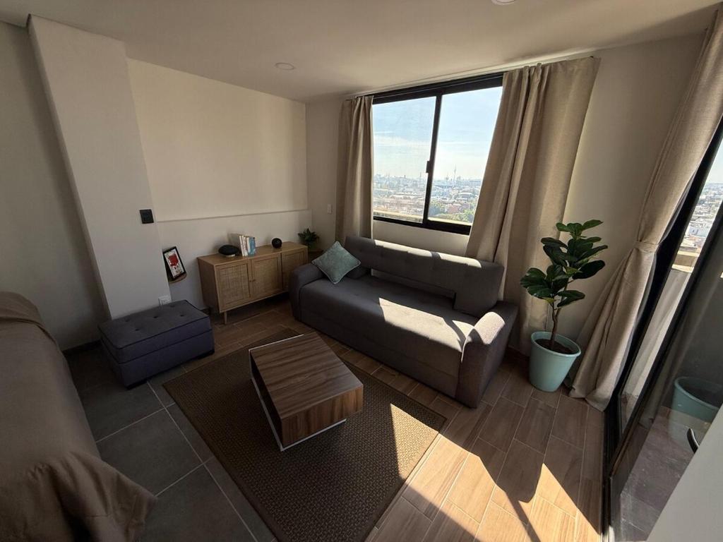 a living room with a couch and a large window at Suite Privada Zona Norte in Miravalle