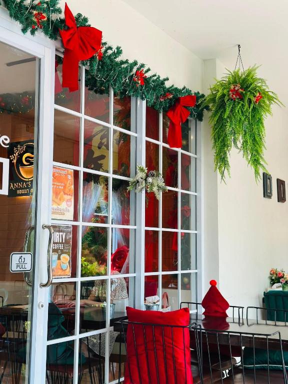 a room with a table with red chairs and christmas decorations at แอนนา เรสซิเดนซ์ in Ban Dung