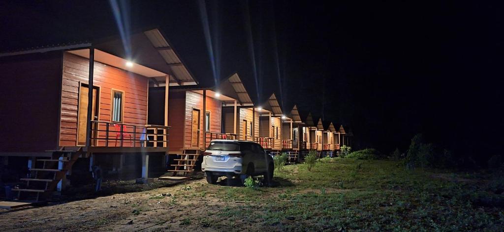 a truck parked next to a row of houses at night at Konglor cave Resort - River side Restaurant in Ban Konglo