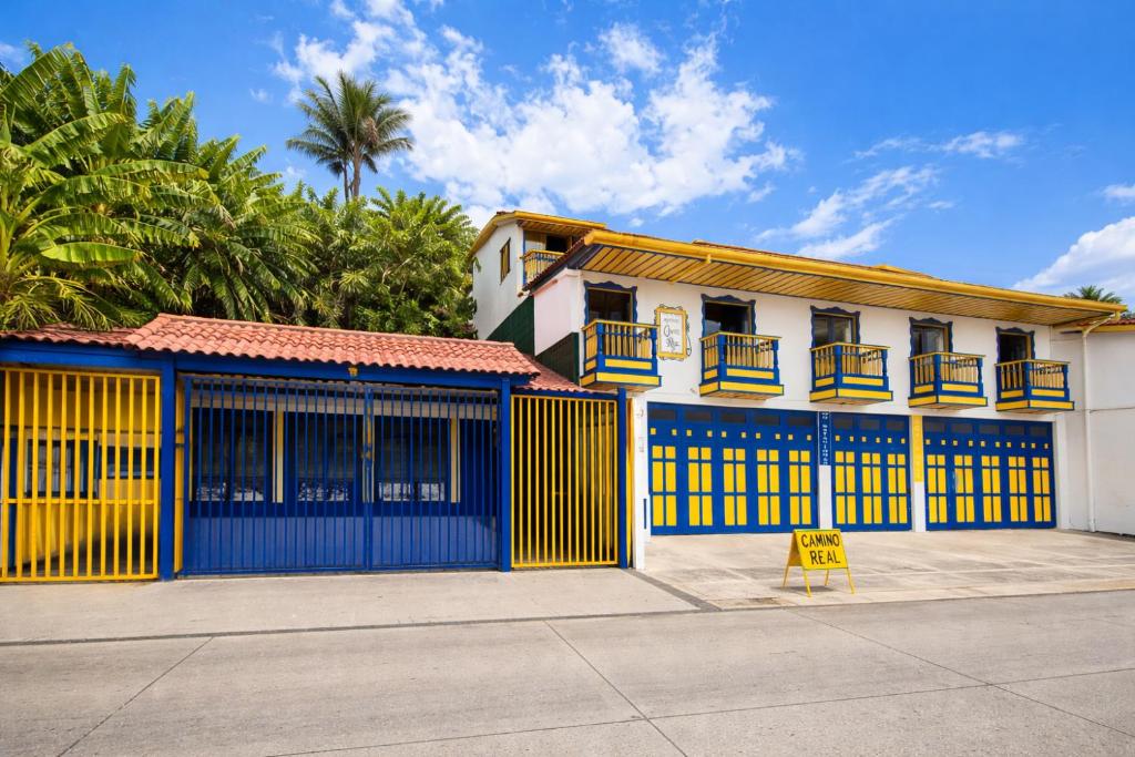 a building with blue and yellow doors and a yellow sign at Hospedaje Camino Real in Salento