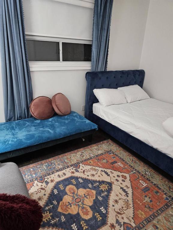 a room with two beds and a couch and a rug at Comfortable Private Room in Toronto