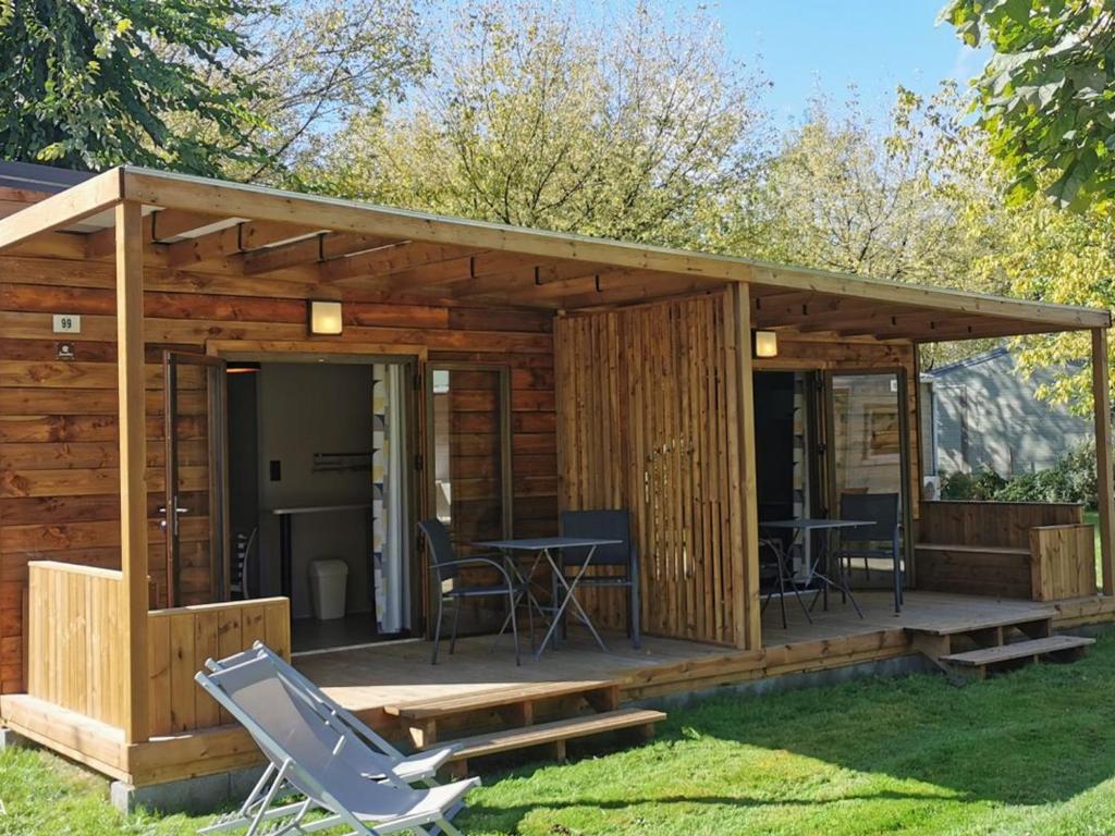 a cabin with a deck with a table and chairs at Chalet avec animaux acceptés - 2 pers. - API-1-52-2308 in Coulon