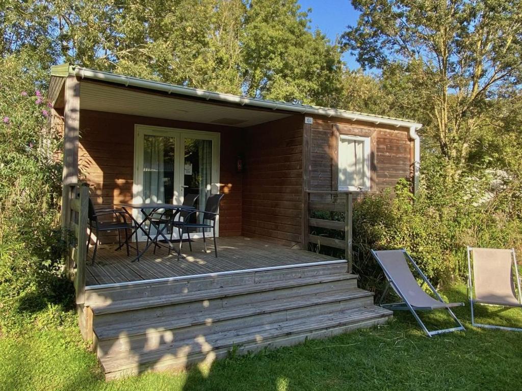 a cabin with a deck with a table and chairs at Chalet clim - 4 pers. - API-1-52-2324 in Coulon