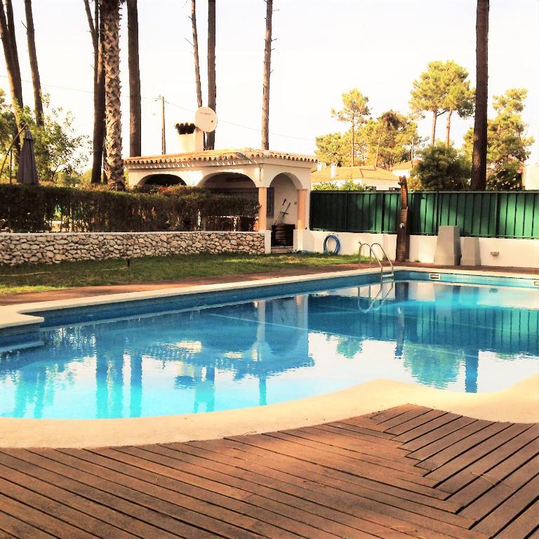 a swimming pool in front of a house at Verdizela Pool & Garden in Charneca