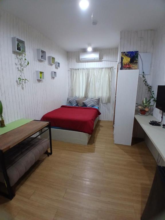 a small room with a bed with a red blanket at Sol house in Pajak