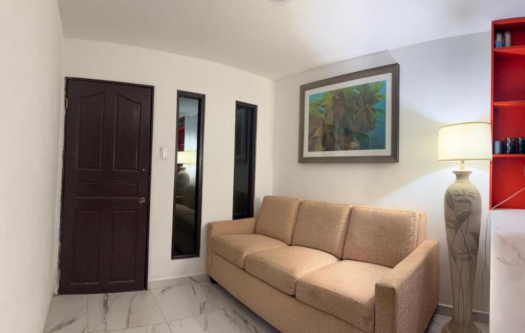 a living room with a couch and a door at Arubaapartamentos in Oranjestad