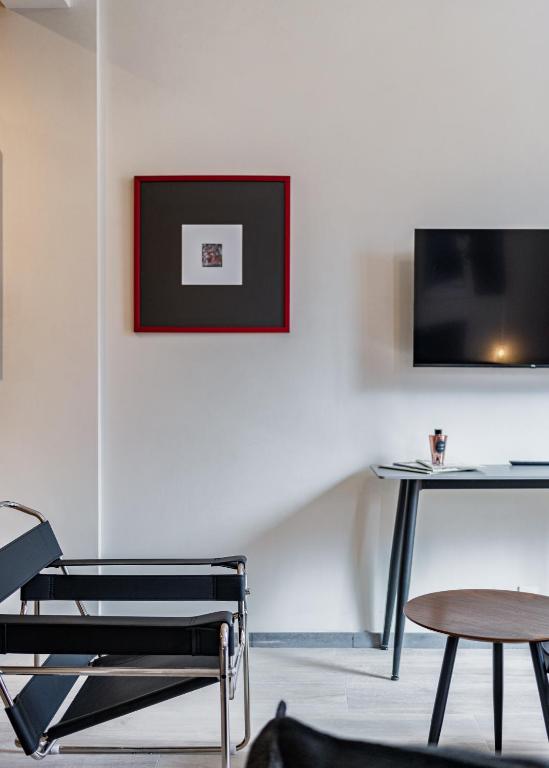 ein Zimmer mit einem Stuhl, einem Tisch und einem Fernseher in der Unterkunft Comfort Luxe Loft near Bellas Artes casaXúla in Mexiko-Stadt
