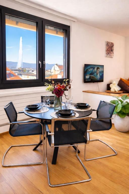 a dining room with a table and chairs and windows at 7Heaven Hypercentral JetView in Geneva