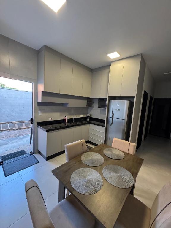 a kitchen with a table and chairs and a refrigerator at New House, Long Stay in Maringá