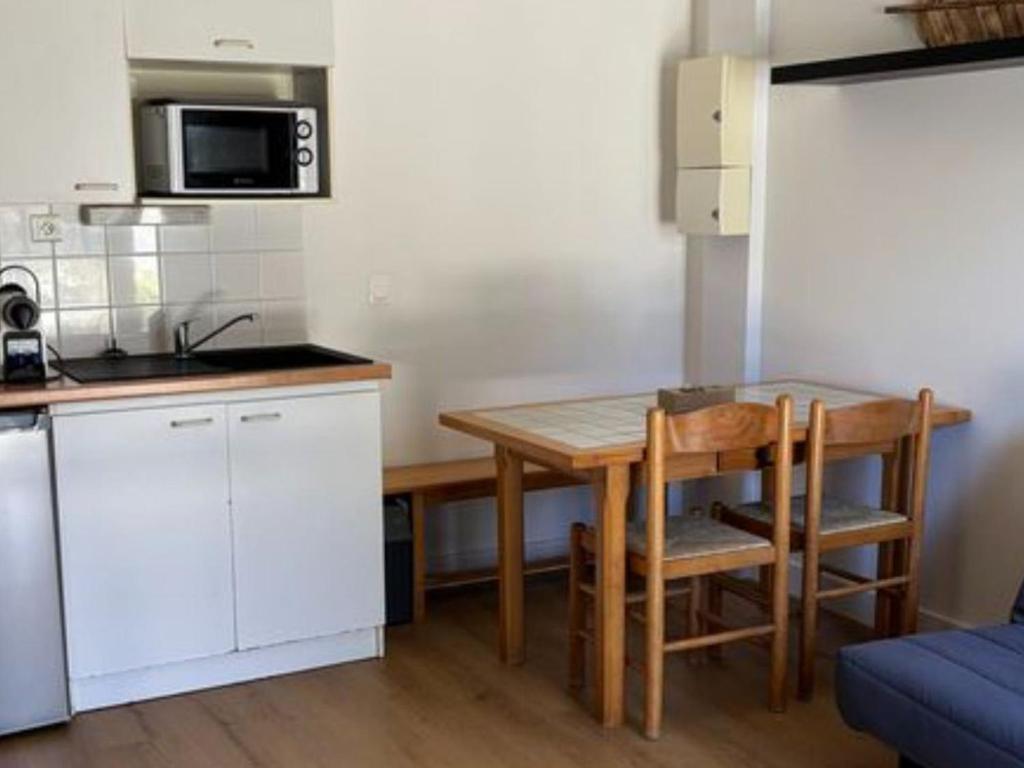 a small kitchen with a table and a microwave at Appartement charmant - 4 pers. - API-1-52-2507 in Saint-Hilaire-de-Riez