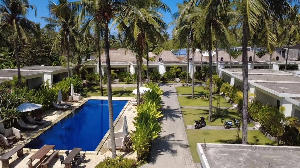 an aerial view of a resort with a swimming pool and palm trees at The Kebon Lombok in Kuta Lombok
