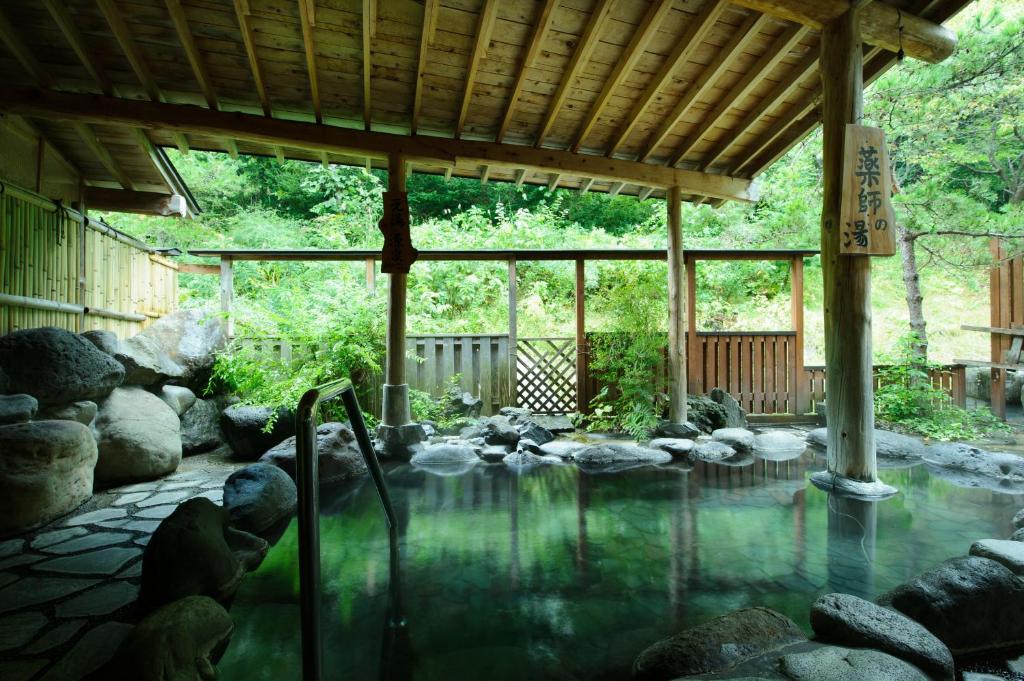 uma piscina de água num pavilhão com pedras em Kawacho em Shizukuishi
