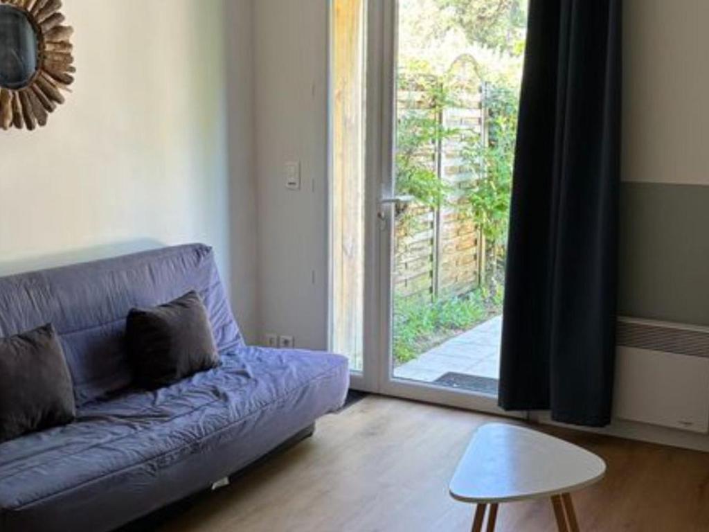 a living room with a purple couch and a sliding glass door at Appartement confortable - 4 pers. - API-1-52-2527 in Saint-Hilaire-de-Riez