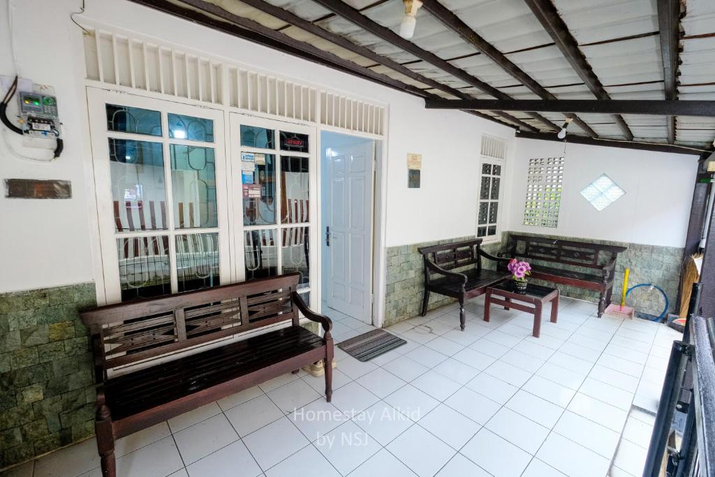 a living room with benches and a table at Homestay Alkid in Timuran