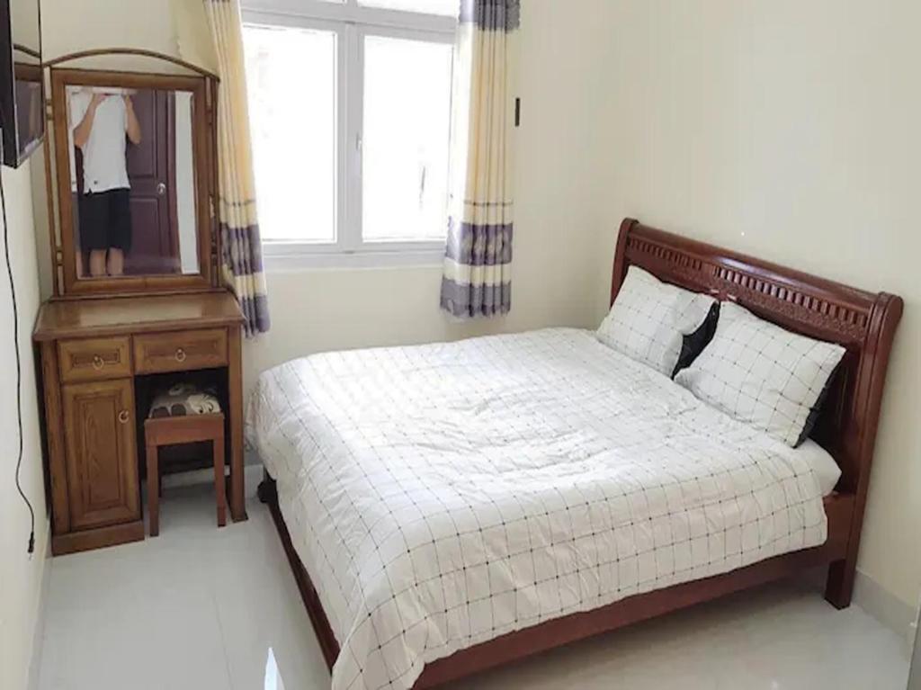 a bedroom with a bed and a mirror and a dresser at Beachside home in Phú Quốc