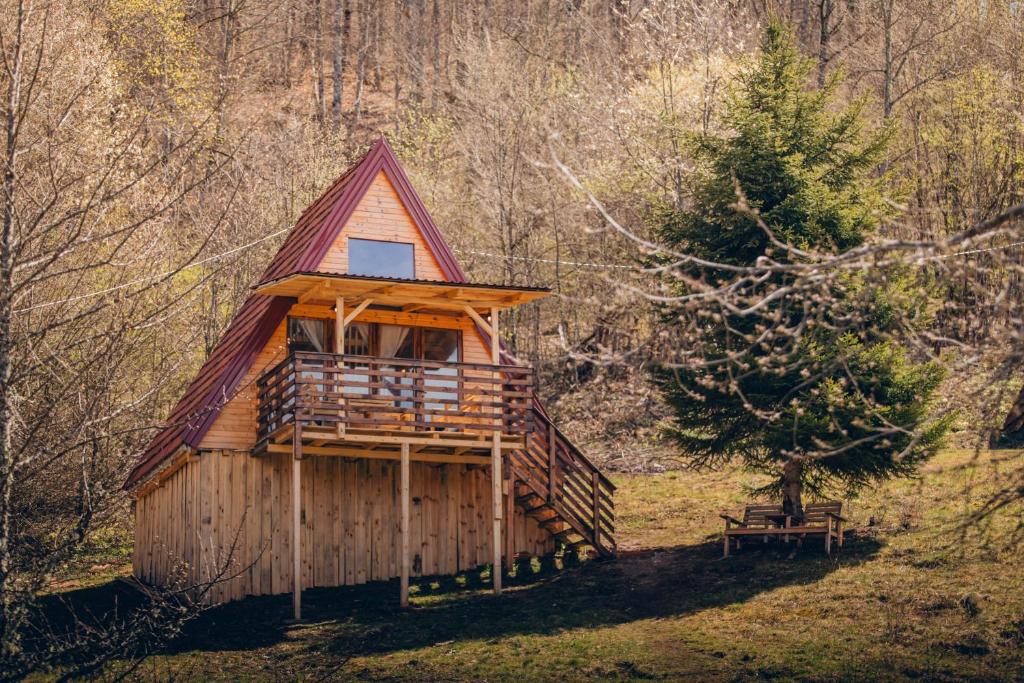 a tree house in the woods with a bench next to it at Mountain View 2 in Tjentište