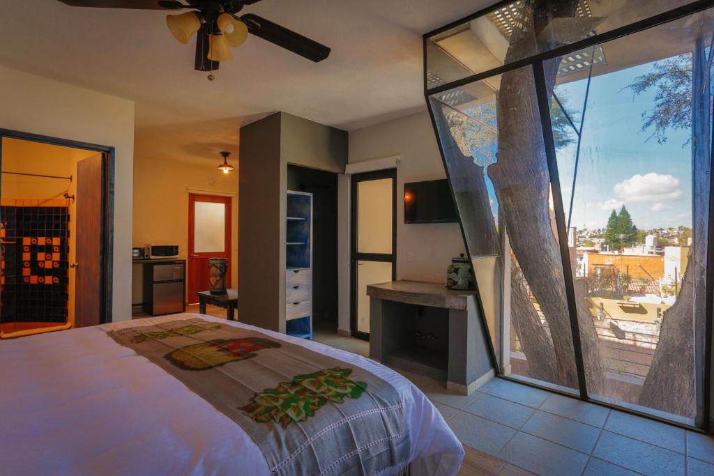 a bedroom with a bed and a large glass window at Casa Naré Adults Only in San Miguel de Allende