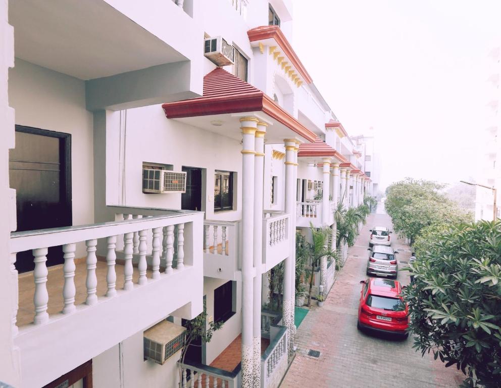 uma rua com edifícios brancos e um carro vermelho em Hotel Kridha Residency - Opposite Prem Mandir Vrindavan em Matura