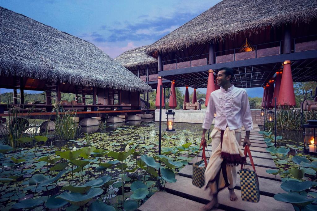 a man standing in front of a pool of water at Jetwing Vil Uyana, A Luxury Reserve in Sigiriya