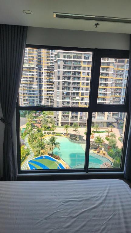 a bedroom with a large window with a view of a resort at 2 Giường view Bể bơi Family Room with Pool view in Long Bình
