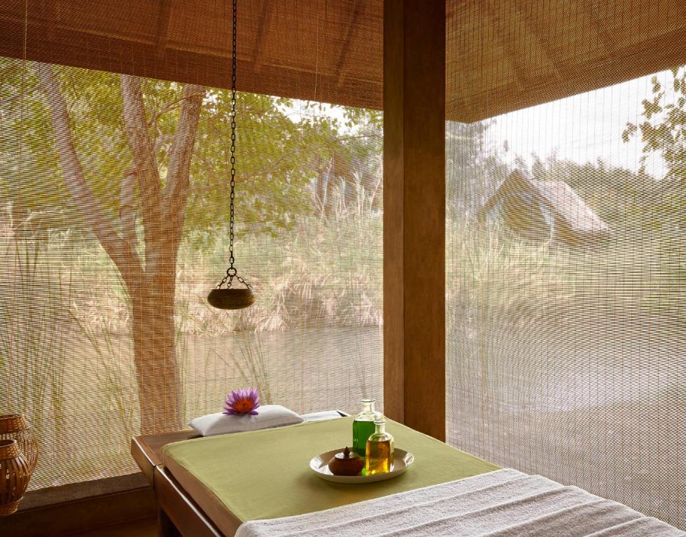 a table in front of a large window with a view of a tree at Jetwing Vil Uyana, A Luxury Reserve in Sigiriya