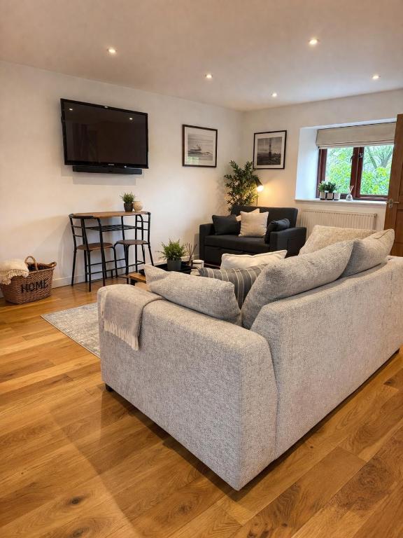 a living room with a couch and a tv at Palmiro Cottage in Lapford
