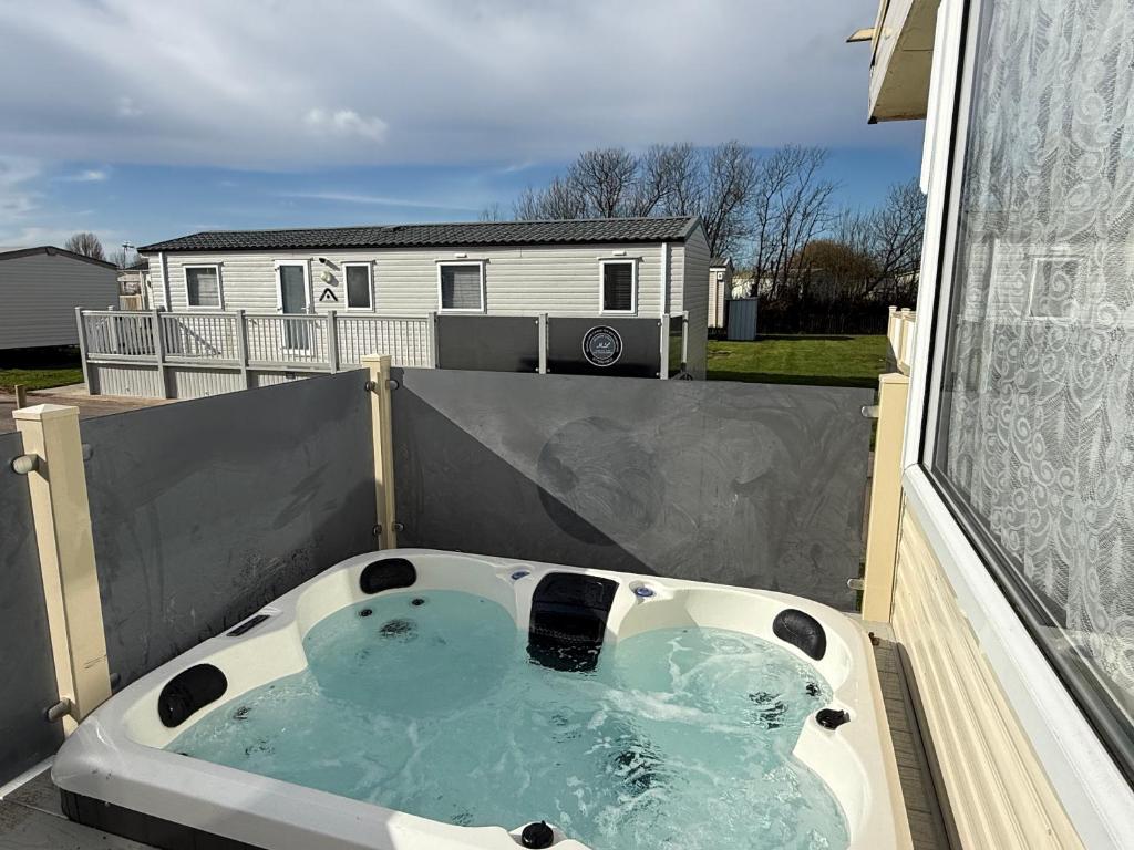 a bath tub with two teddy bears in it at Sunnymede G20 with Hot Tub - pet friendly, Wifi, bed linen - Meadow Lakes Caravan & Lodge Hire in Ingoldmells