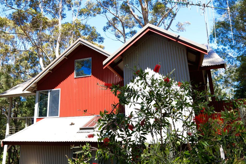 a red house with a tree in front of it at Pelicans at Denmark in Denmark