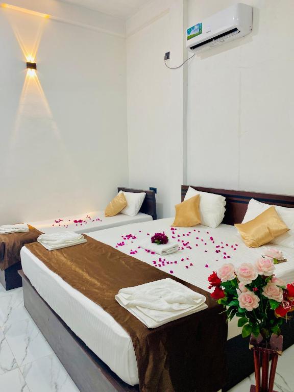 a bedroom with two beds with flowers on it at Calm Night Surf Stay in Arugam Bay