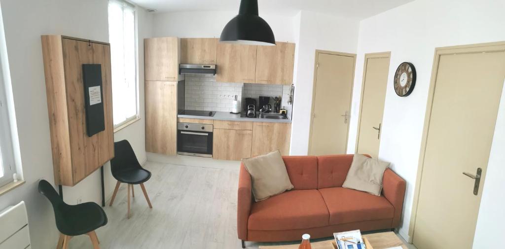 a living room with a couch and a kitchen at La Monaco du Nord in Granville