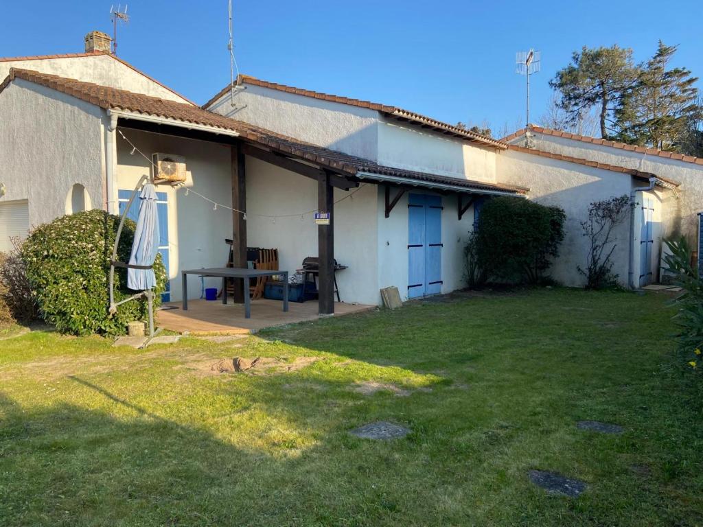 a white house with a picnic table in the yard at La Faute Sur Mer in La Faute-sur-Mer