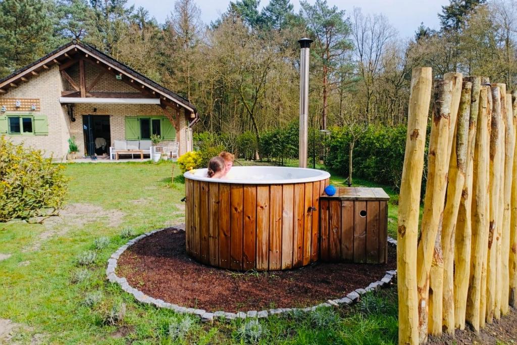 Ein Hund sitzt in einem Whirlpool im Garten in der Unterkunft Chalet Chalazy in Lille