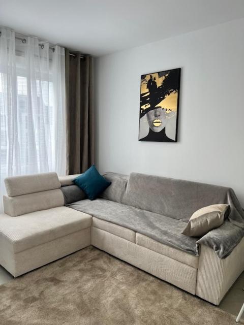 a living room with a couch and a painting on the wall at Centre-ville de Saint-Brieuc in Saint-Brieuc