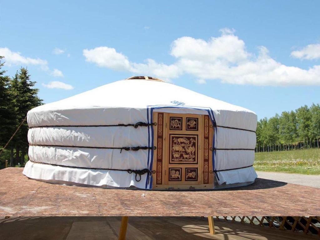 a yurt with a wooden door on a table at モンゴルゲルグランピング Frontier Village in Tōma