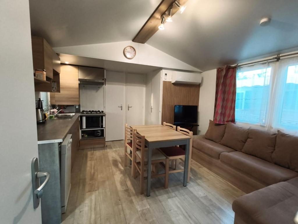 a kitchen and living room with a table and a couch at Eucalyptus 24 du samedi au samedi location in Valras-Plage
