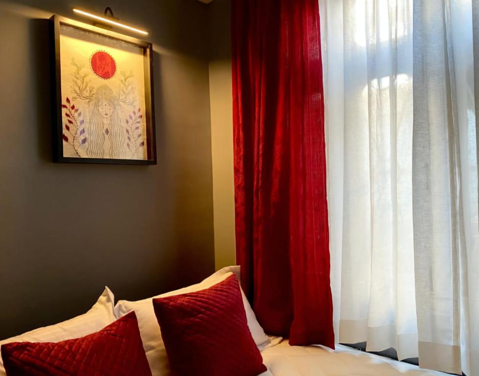 a bed with red curtains next to a window at Mayuri Lodge in Kalimpong