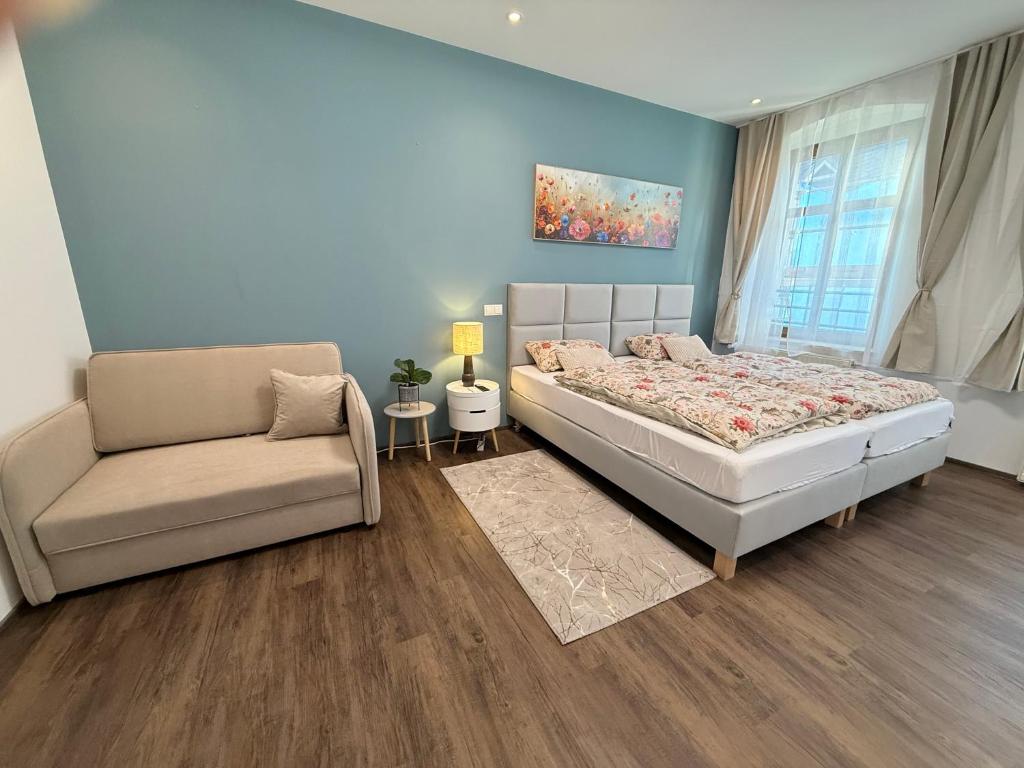 a bedroom with a bed and a couch at Apartmenthaus Döbeln Zentrum in Döbeln