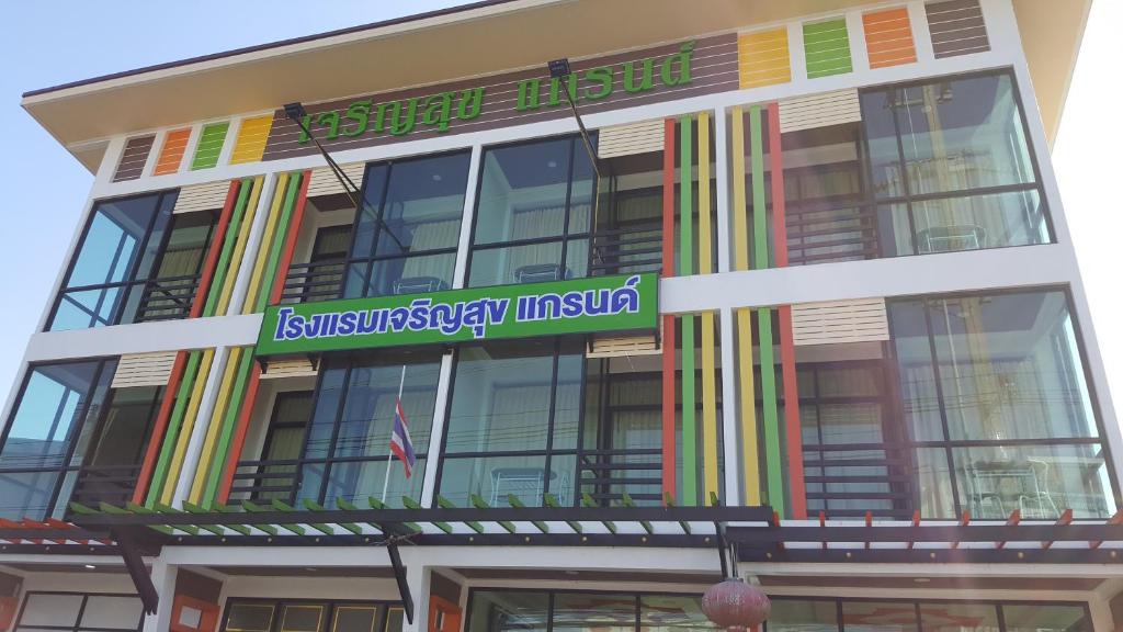 a building with a sign on the side of it at Charoensuk Grand Hotel in Kabin Buri