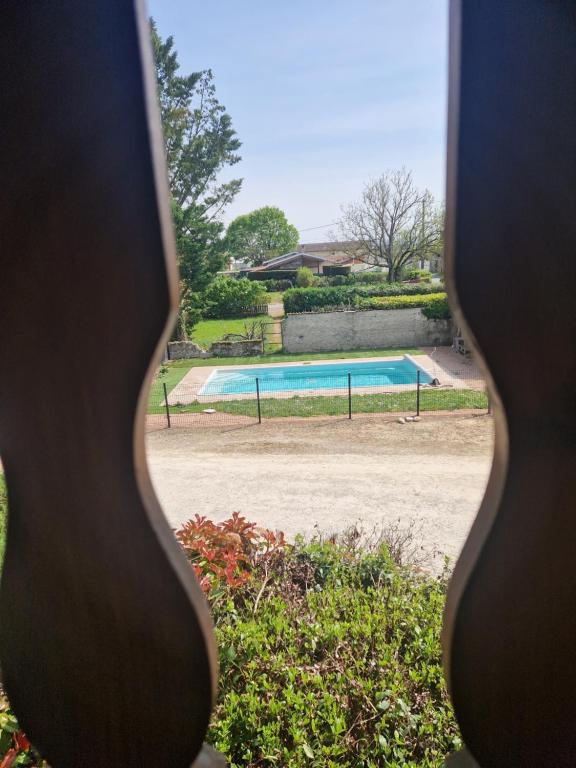 Blick auf ein Schwimmbecken durch ein Fenster in der Unterkunft La ferme de Rapan Pérouges in Pérouges