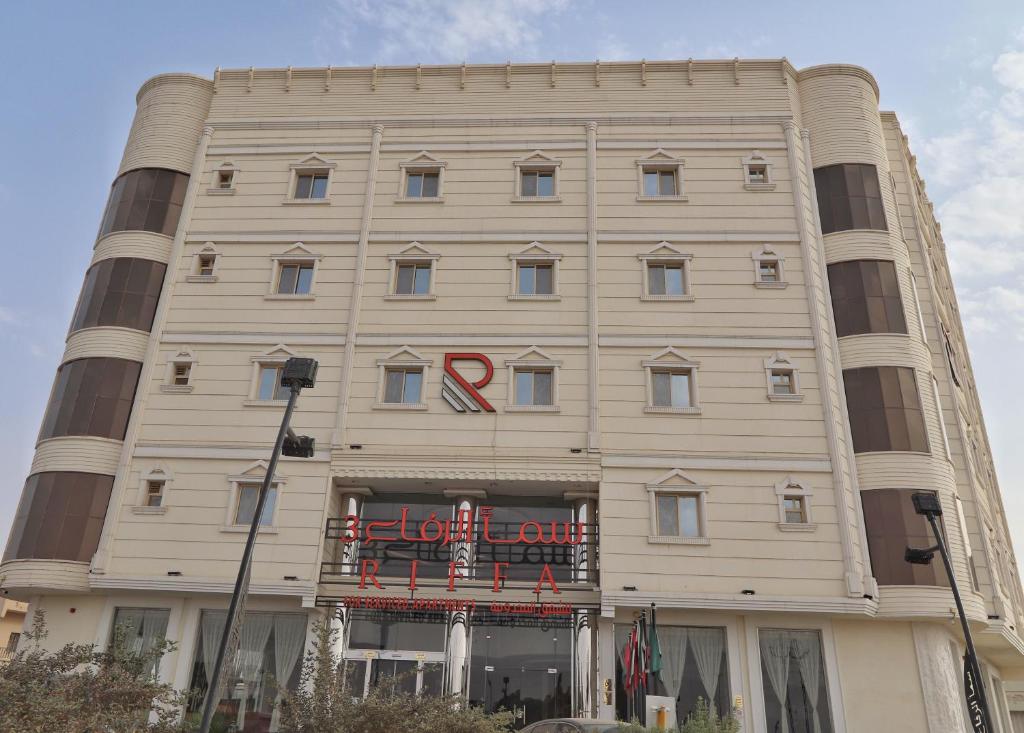 a large white building with a red sign on it at شقق سما الرفاع للشقق المخدومة in Al Kharj
