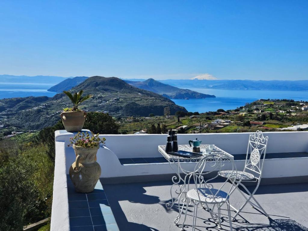 a table and chairs on a balcony with a view of the ocean at Villa Paradiso - spectacular sea view over volcanoes in Piano Conte