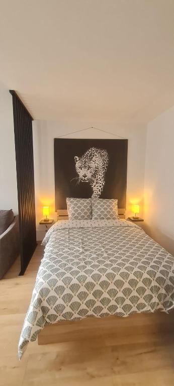 a bedroom with a bed with a black and white comforter at Studio proche Cathédrale in Autun