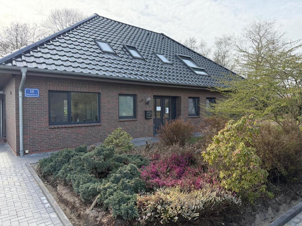a brick house with skylights on the roof at Ferienwohnung Moorblick in Osten