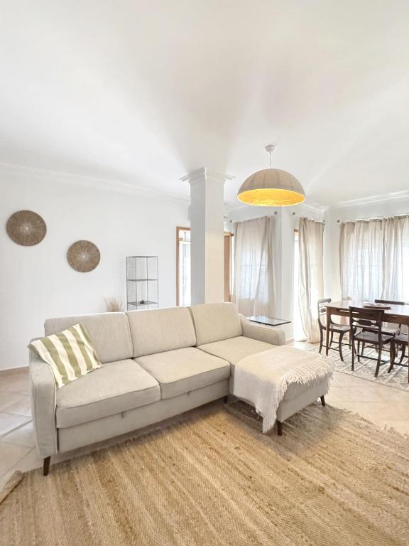 a white living room with a couch and a table at Casa da Maria - T1 perto da praia do Baleal com piscina in Ferrel