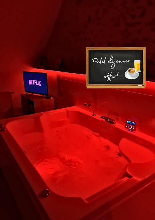 a red bathtub with a sign that says put yourself ahead at La Suite Etoilée - Balnéo privative in Courgains